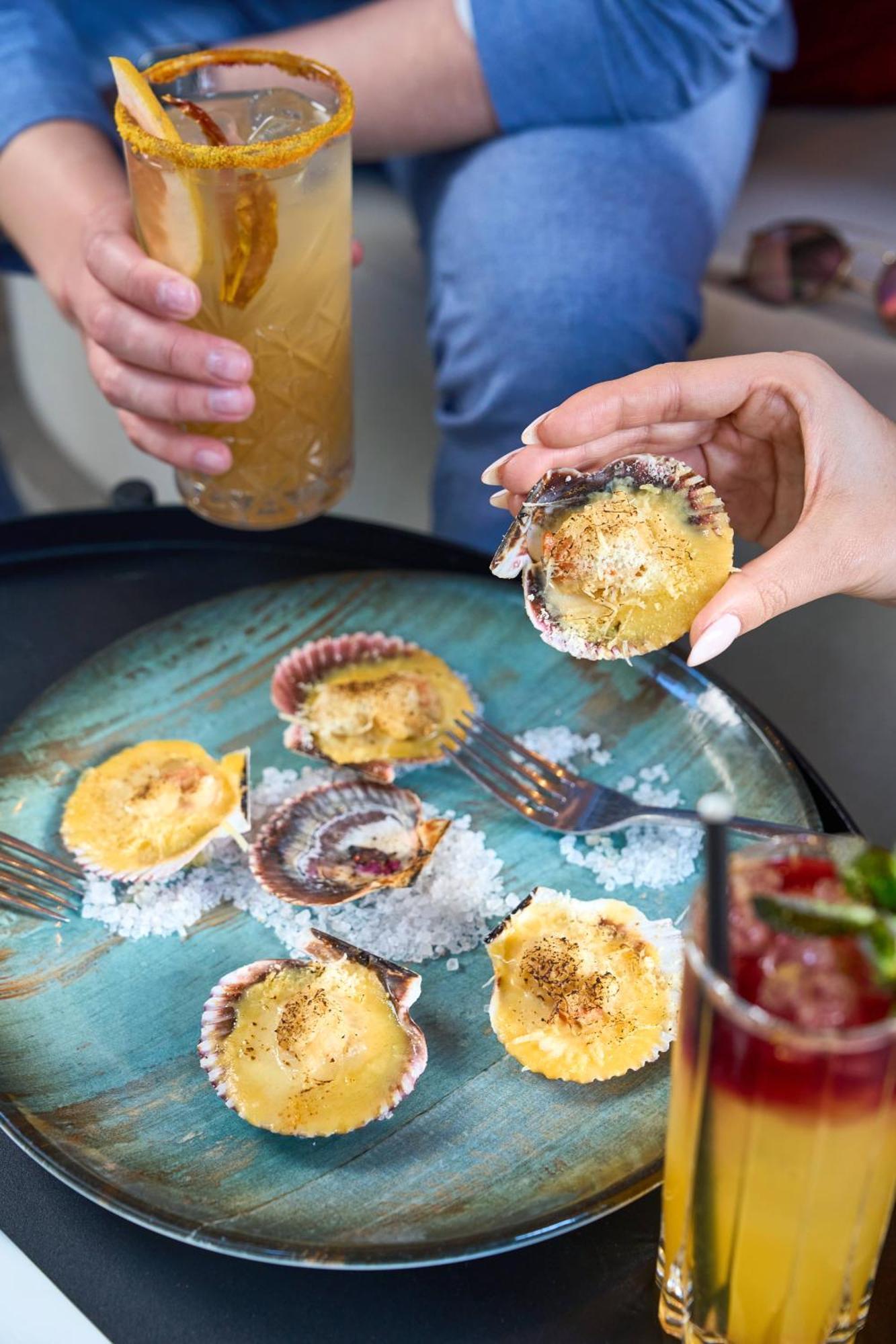 Pullman Santiago Vitacura Exterior foto A woman holding a scallop