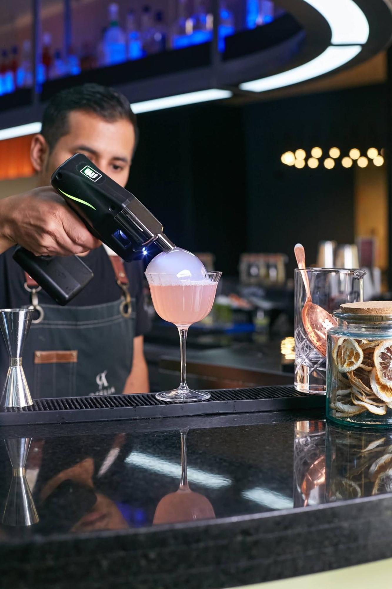 Pullman Santiago Vitacura Exterior foto A bartender using a blowtorch to cook a cocktail